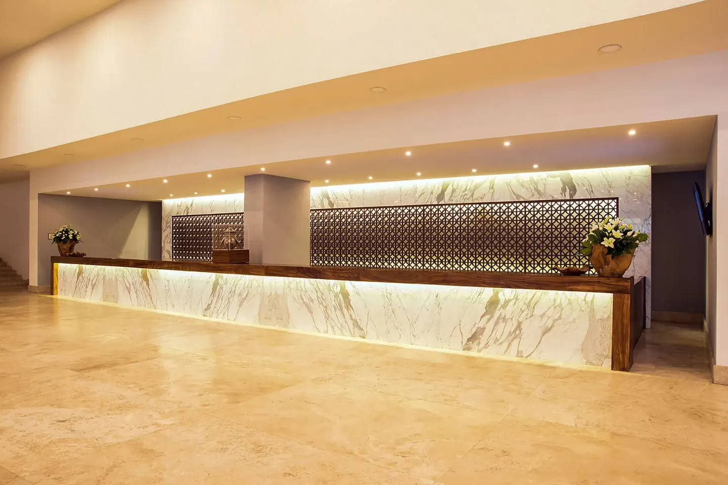 Front desk with marble panels and wood trim at Sheraton Buganvilias Puerto Vallarta.