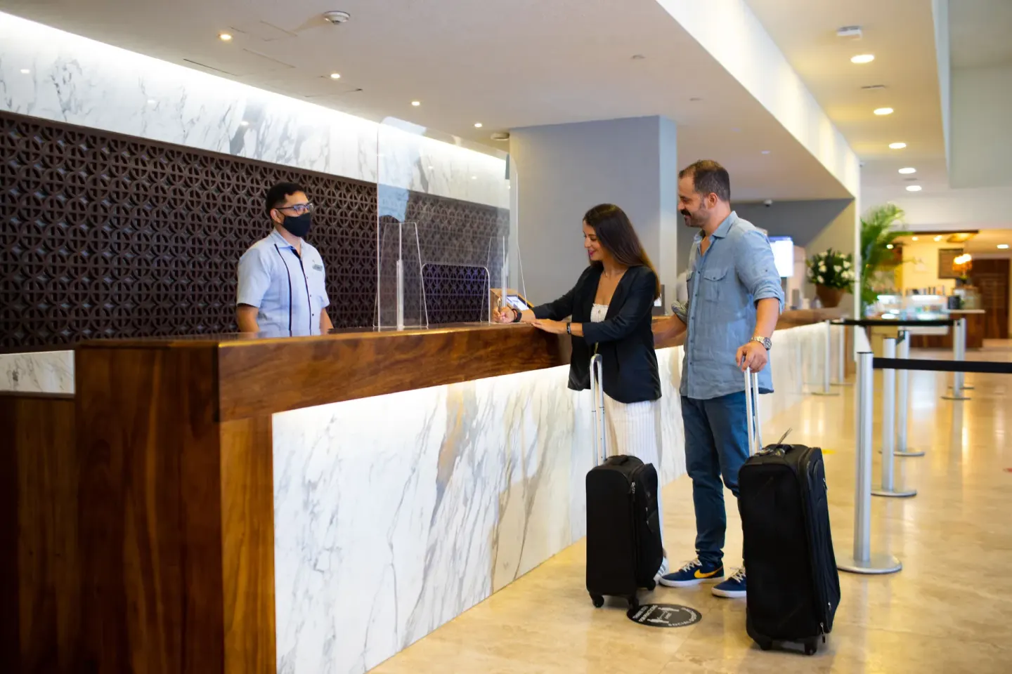 Guests checking in with luggage at the front desk of Sheraton Buganvilias Puerto Vallarta.