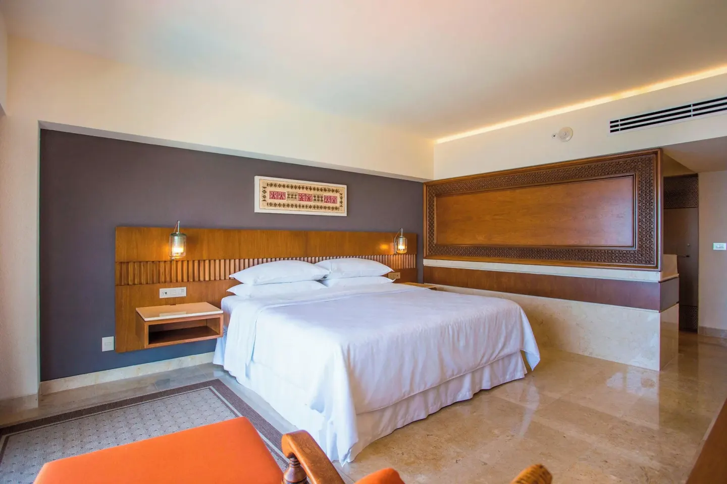 King bed guest room with carved wall panel at Sheraton Buganvilias Puerto Vallarta.