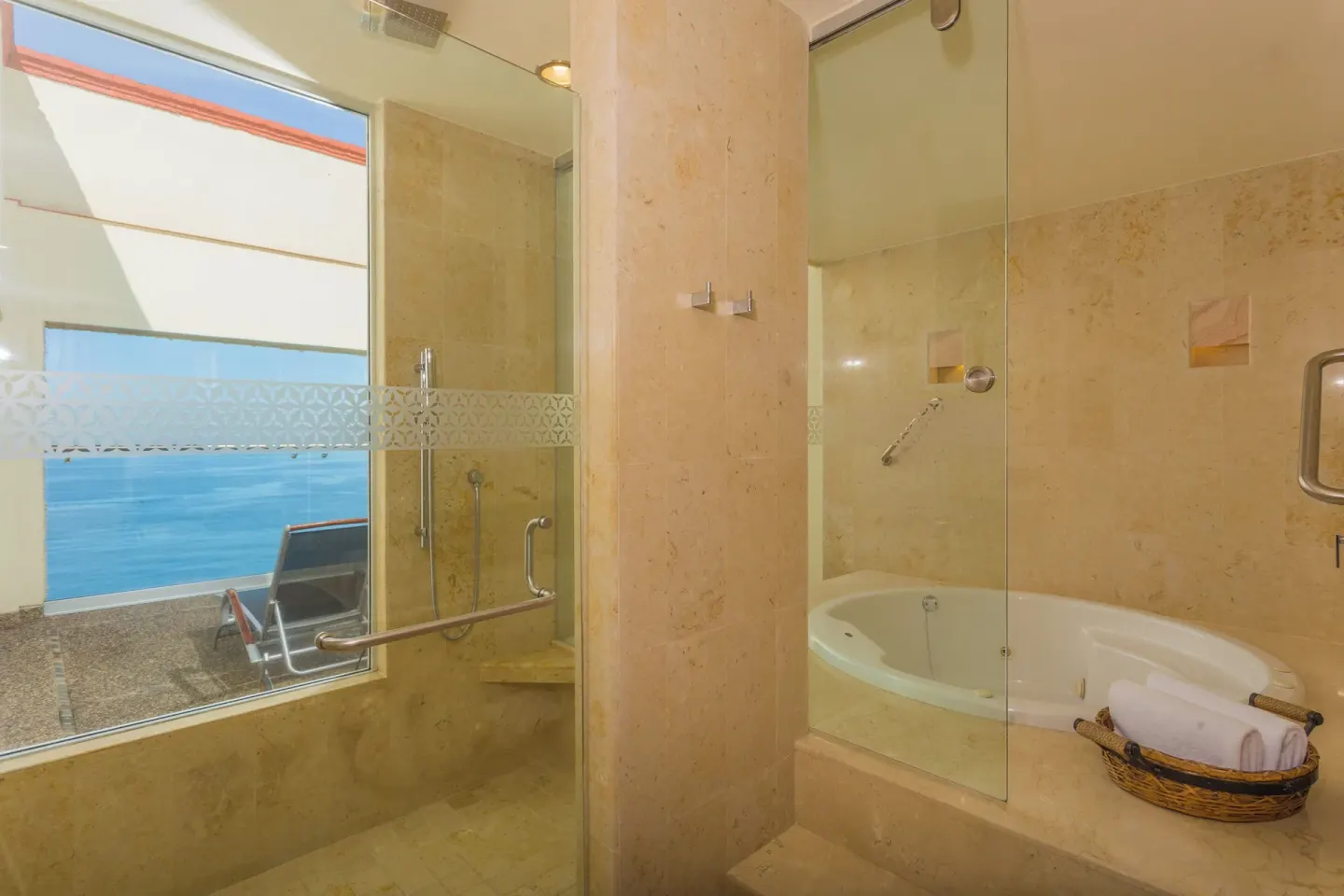Bathroom with shower, tub, towels, and ocean-view window at Sheraton Buganvilias Puerto Vallarta.