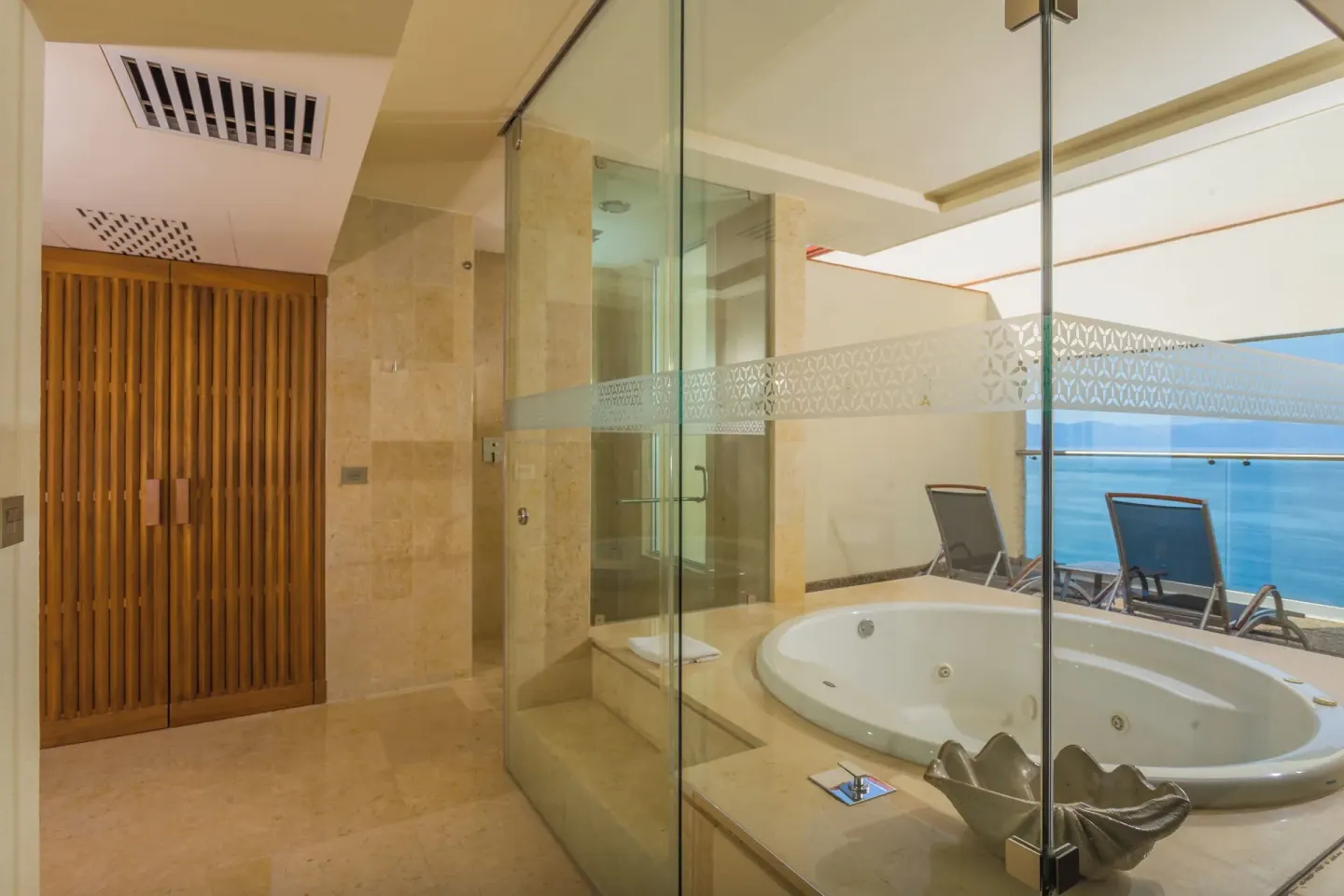 Bathroom with glass shower, whirlpool tub, and ocean terrace view at Sheraton Buganvilias Puerto Vallarta.