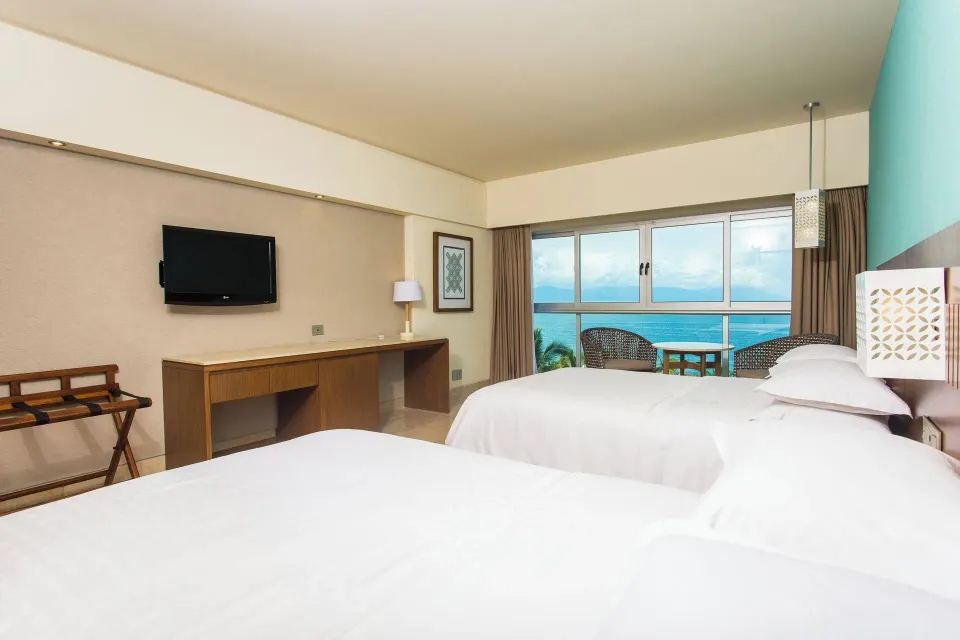 Deluxe Ocean View room with two beds and desk at Sheraton Buganvilias Puerto Vallarta.