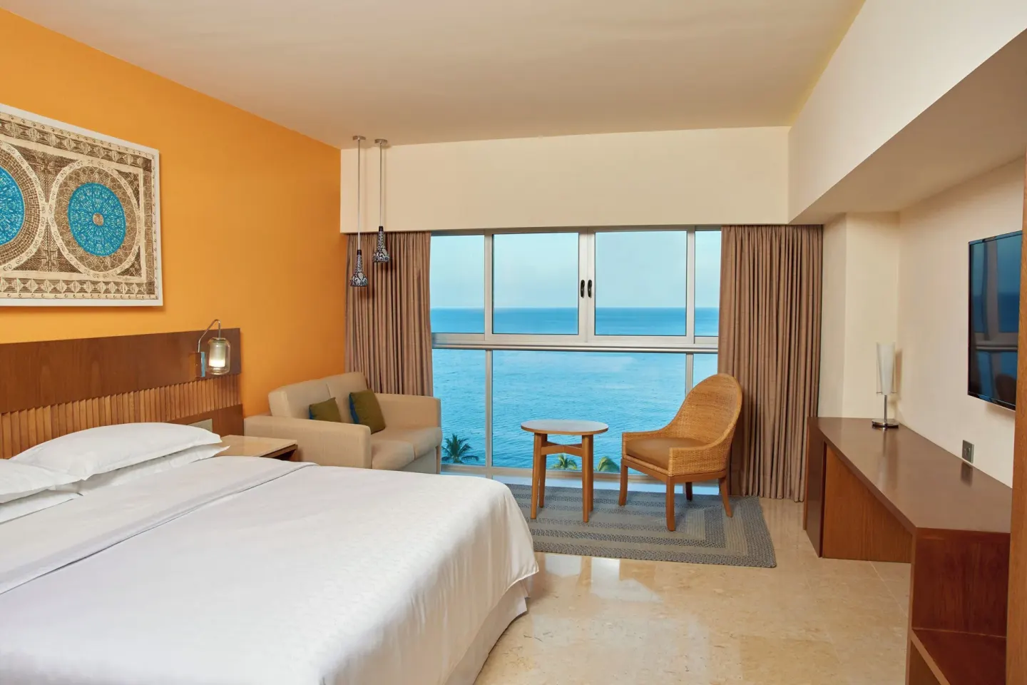 Signature Room king bed with ocean-view windows at Sheraton Buganvilias Puerto Vallarta.