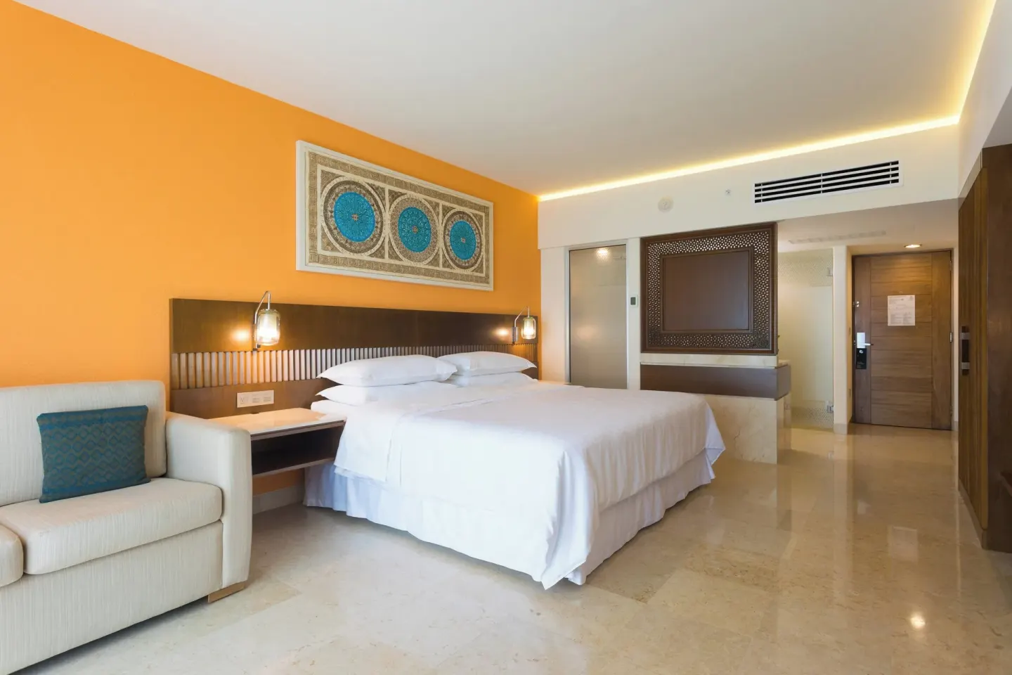 Signature Room king bed and seating area at Sheraton Buganvilias Puerto Vallarta.