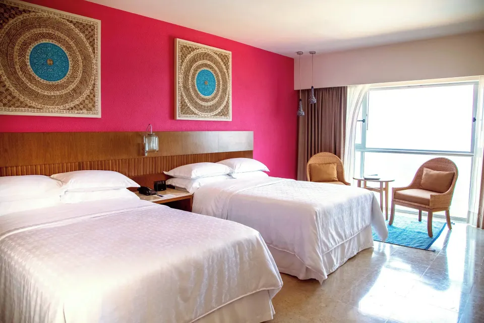 Signature Room with two beds and window seating at Sheraton Buganvilias Puerto Vallarta.