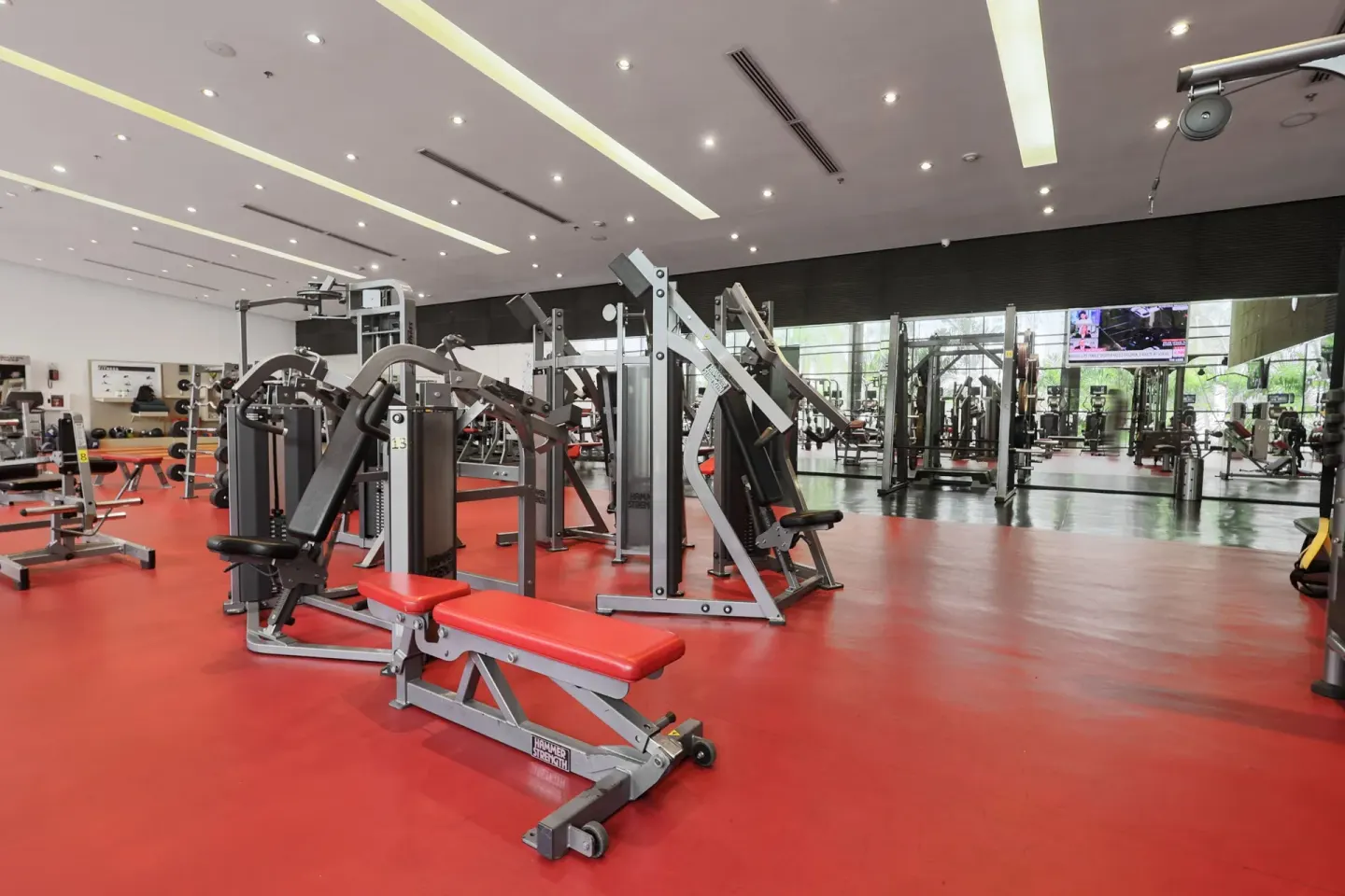 Fitness center benches and machines on red flooring at Sheraton Grand Panama.