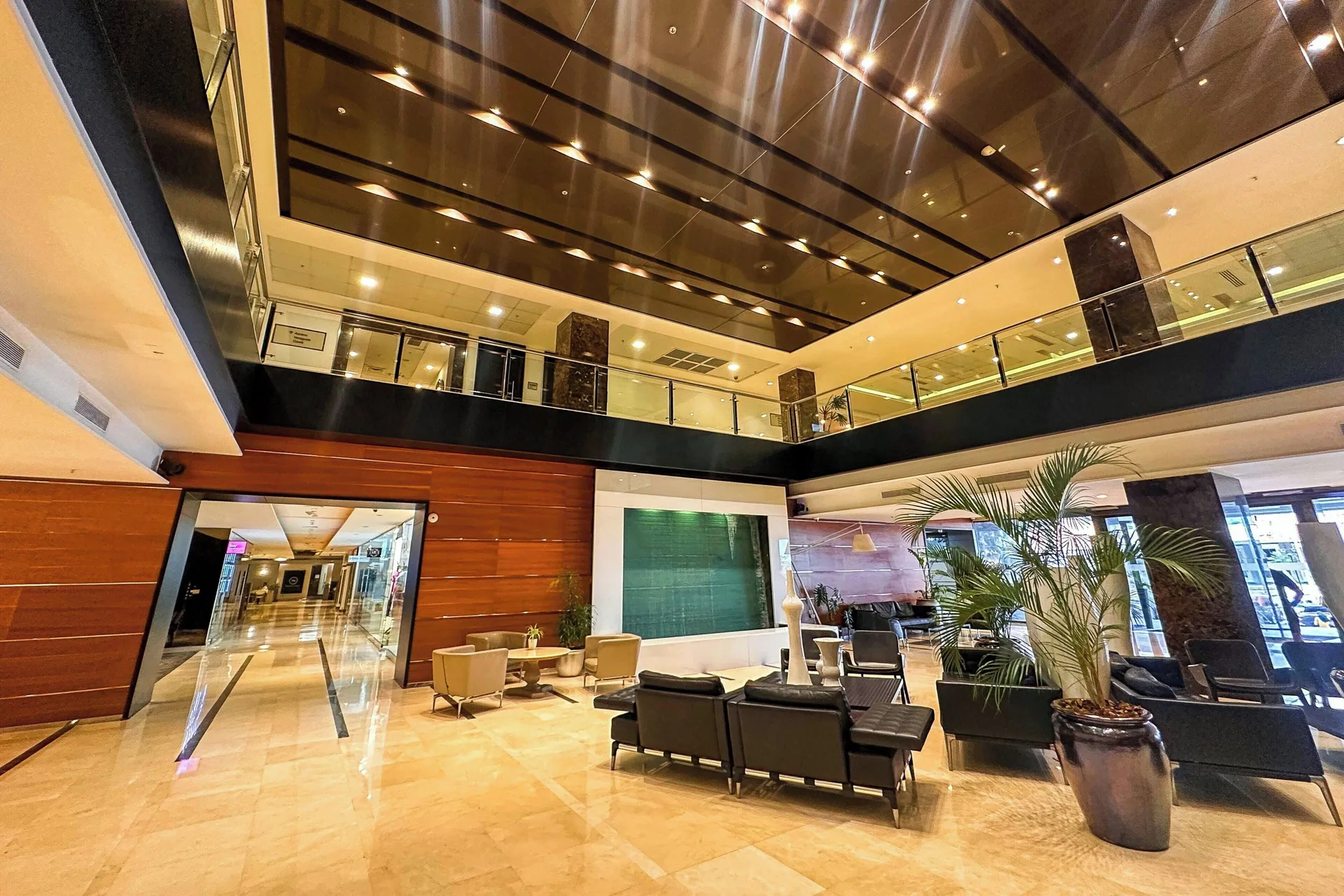 Tall lobby atrium with seating and glass railings at Sheraton Grand Panama.