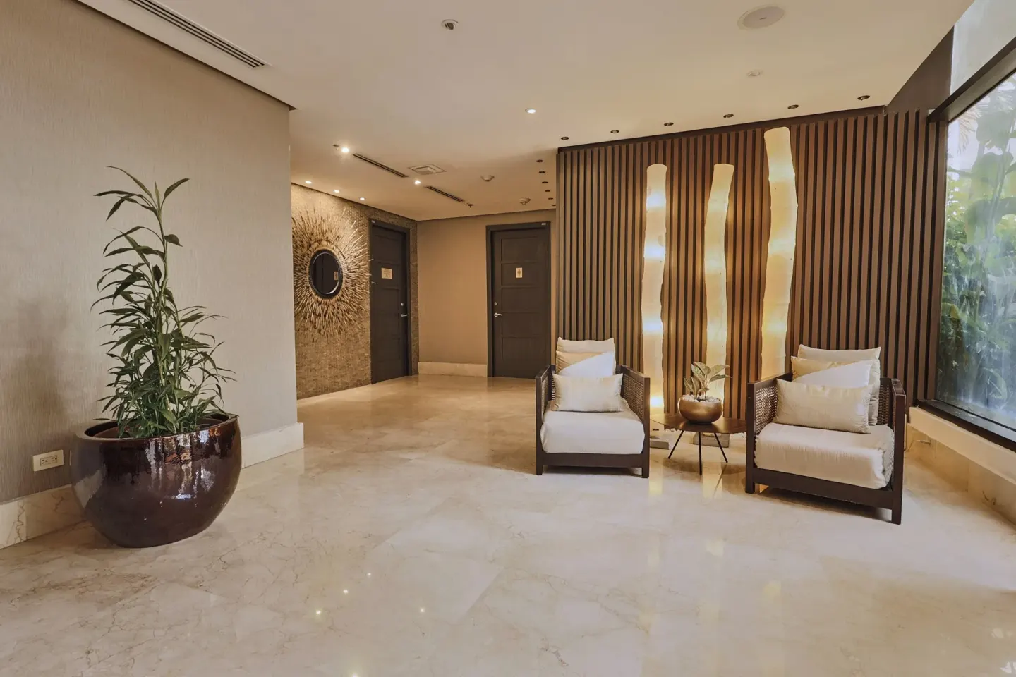 Seating nook with armchairs and potted plant in the spa area at Sheraton Grand Panama.