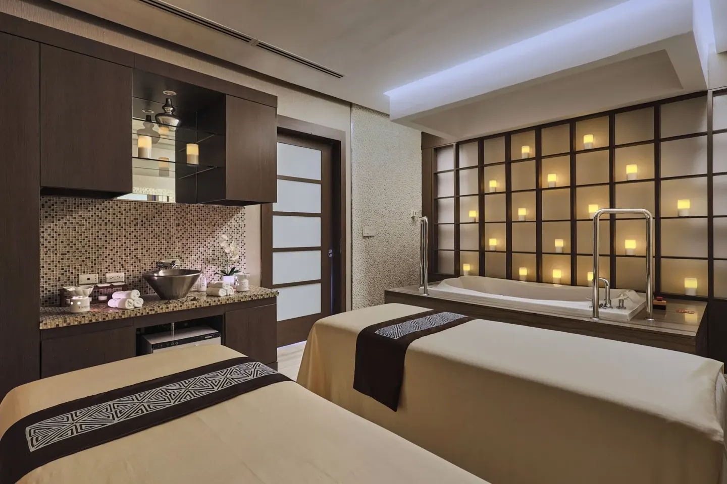 Spa room with two massage beds, mosaic counter, and soaking tub at Sheraton Grand Panama.