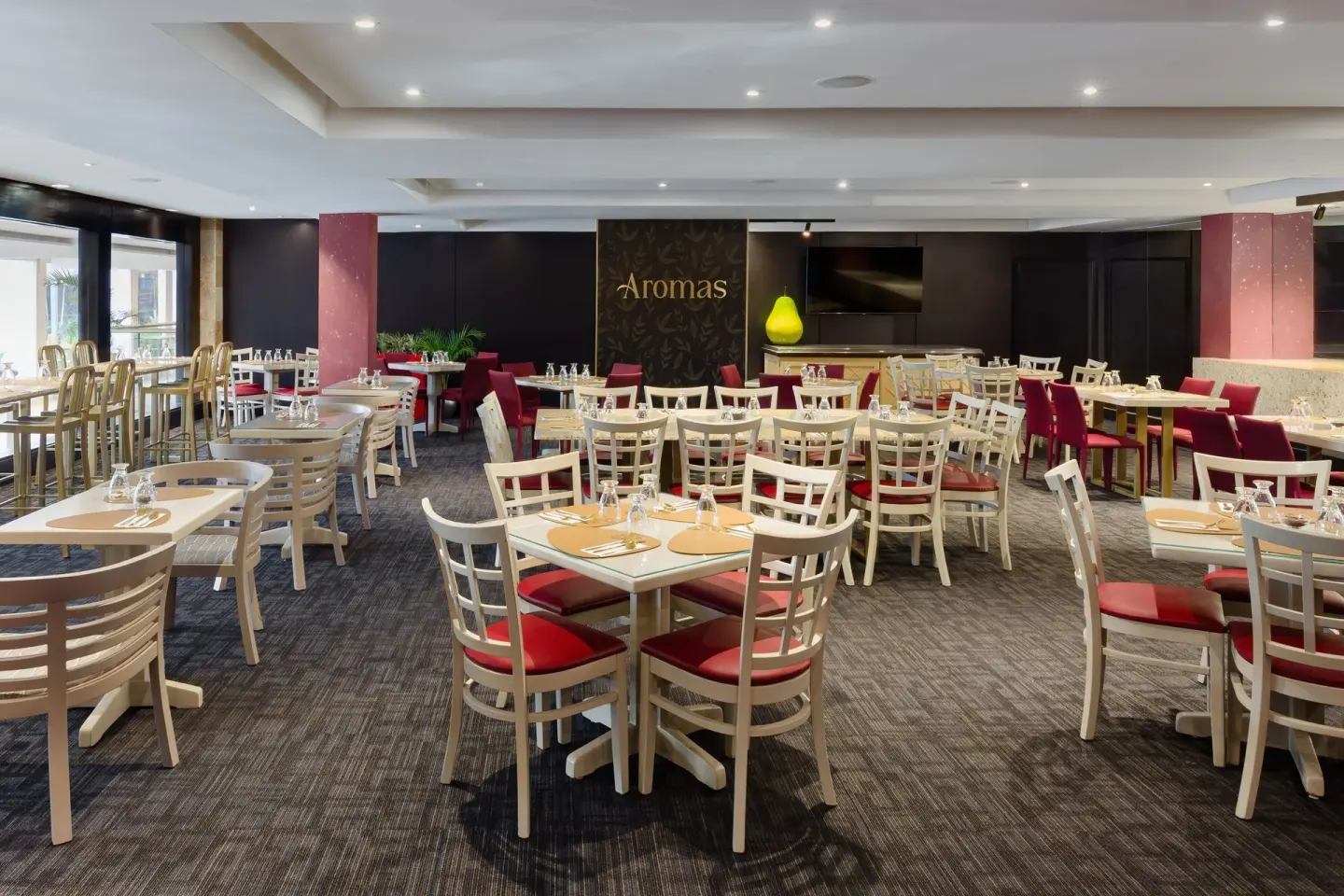 Aromas dining room with set tables and red chairs at Sheraton Grand Panama.