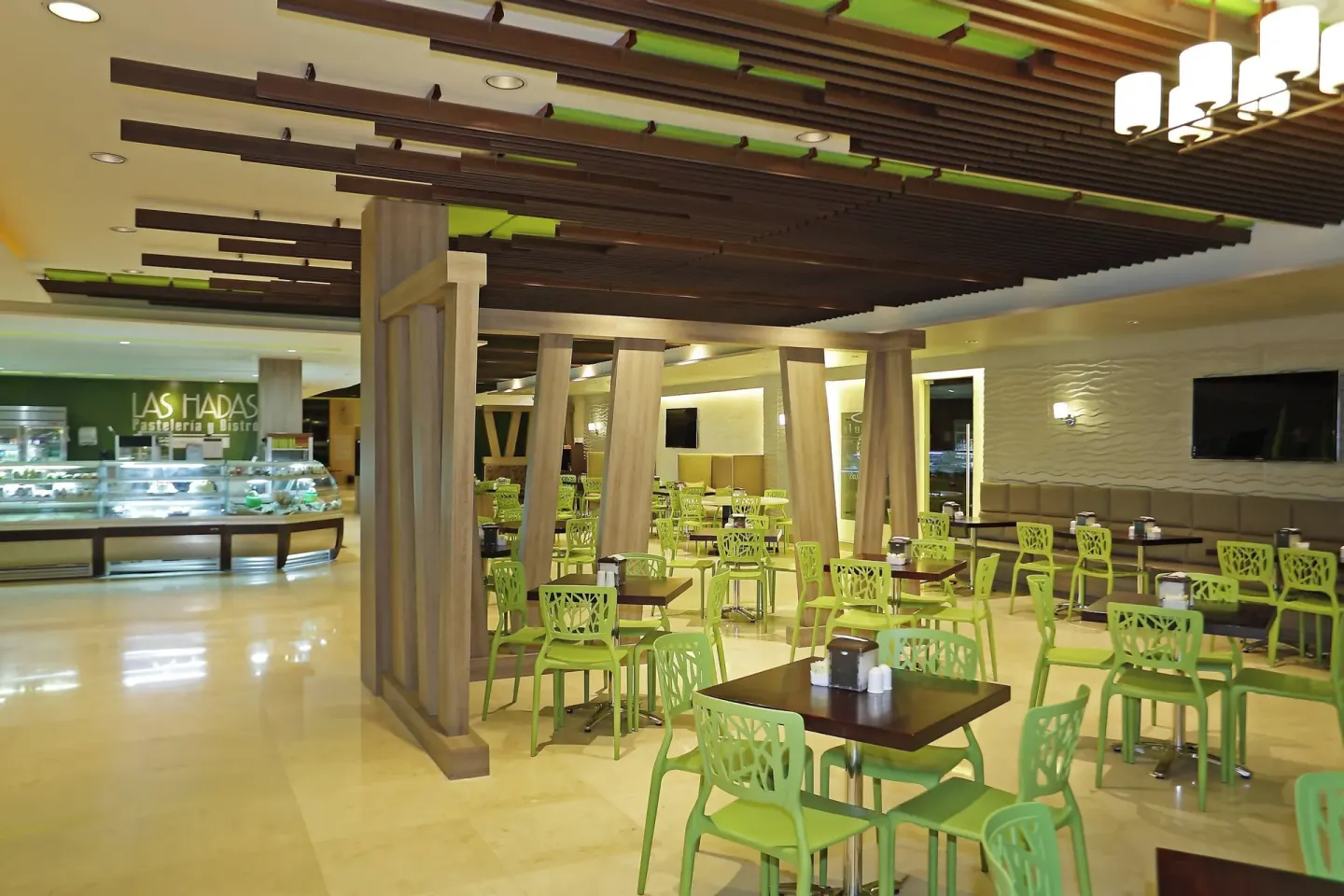 Las Hadas dining area with green chairs and pastry cases at Sheraton Grand Panama.