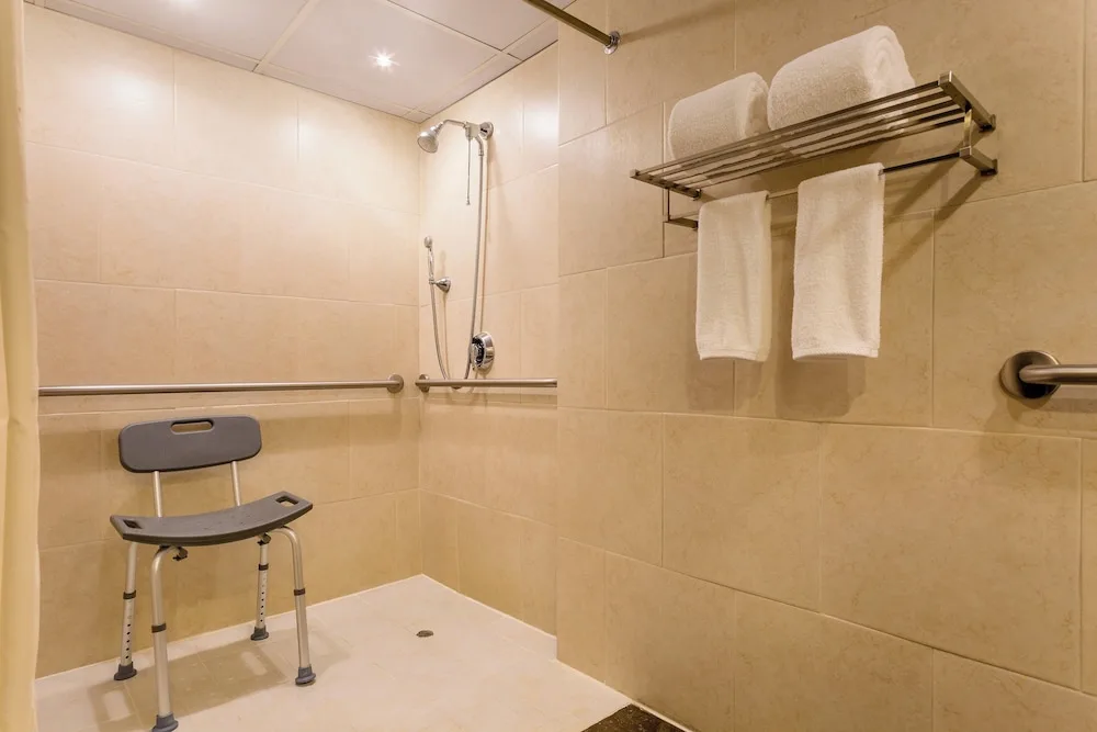 Accessible shower with bench, grab bars, and towel shelf at Sheraton Grand Panama.