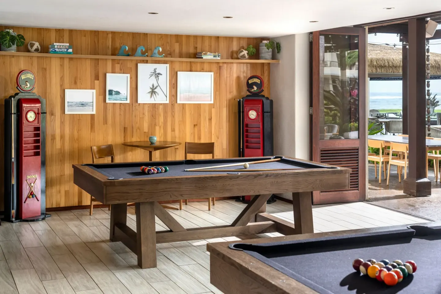 Billiards tables stand beside open doors at Sheraton Kauai Coconut Beach Resort.