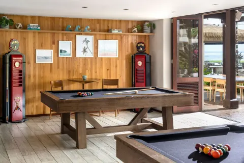 Billiards tables stand beside open doors at Sheraton Kauai Coconut Beach Resort.