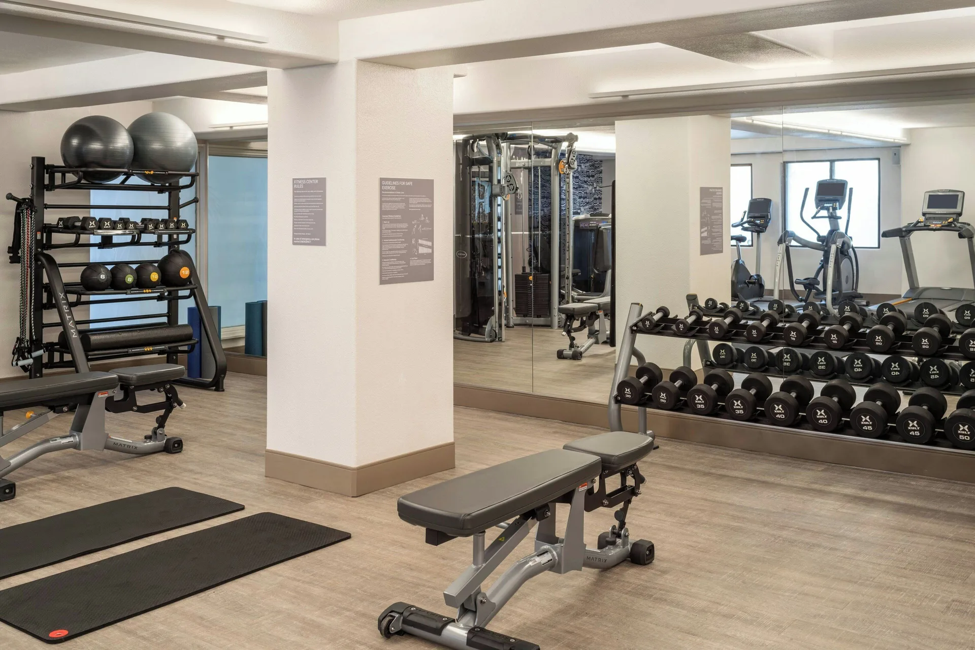 Fitness room with dumbbells, benches, mats and cable equipment at Sheraton Kauai Coconut Beach Resort.
