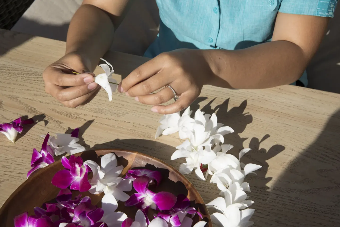 Hands string a flower lei at Sheraton Kauai Coconut Beach Resort.