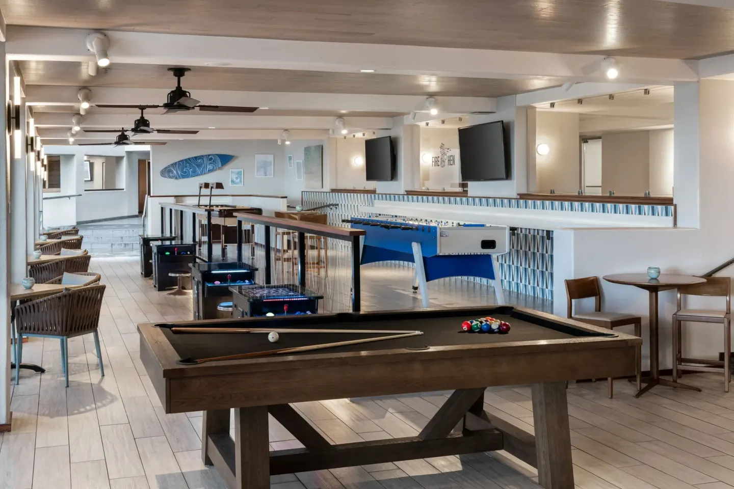 Game room with billiards, foosball, and screens at Sheraton Kauai Coconut Beach Resort.