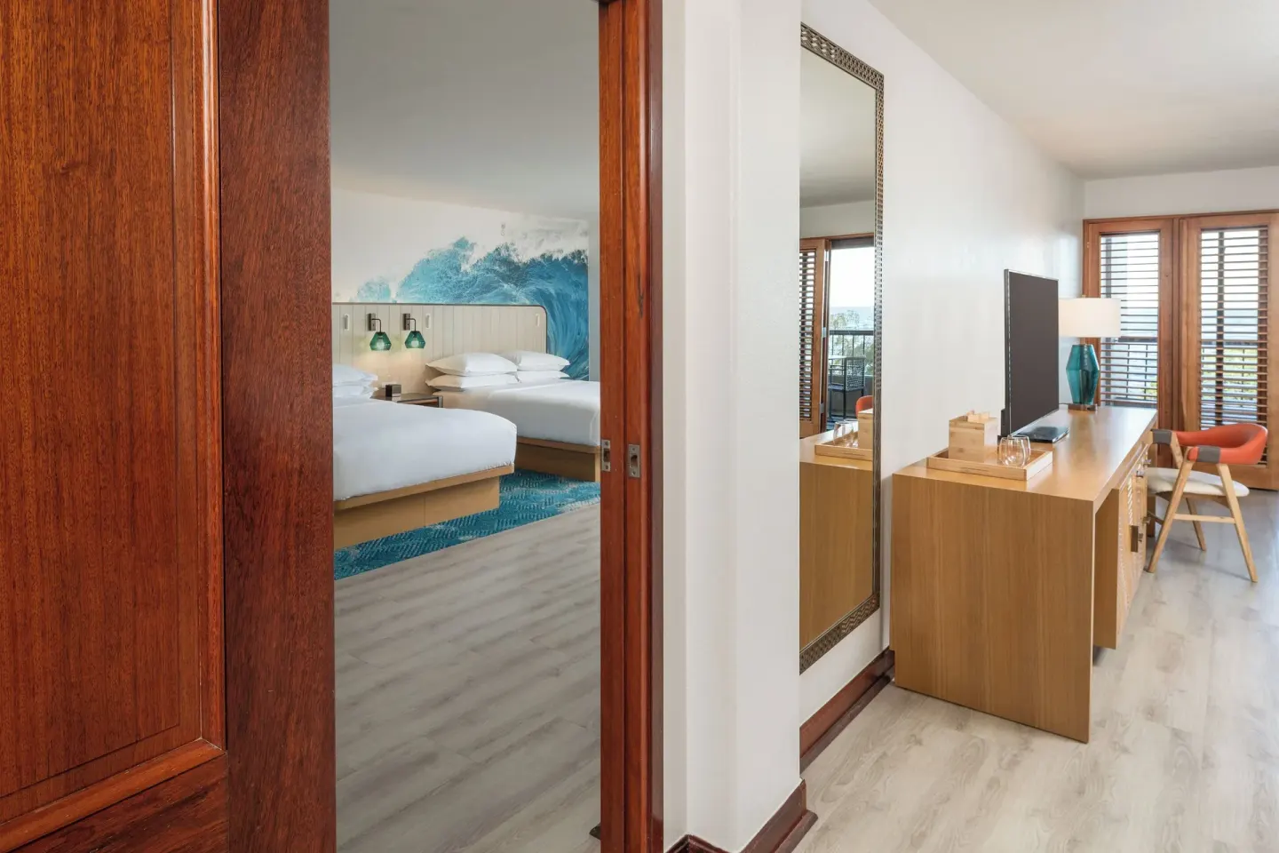 Guest room entry with two beds and desk at Sheraton Kauai Coconut Beach Resort.