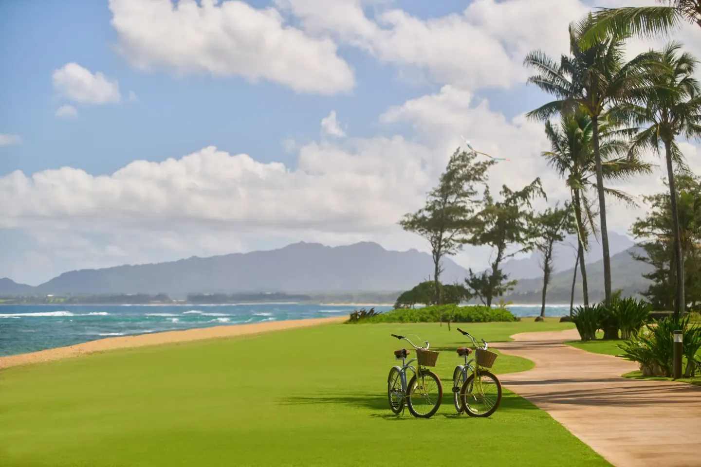 Two bicycles rest near the oceanfront path at Sheraton Kauai Coconut Beach Resort.