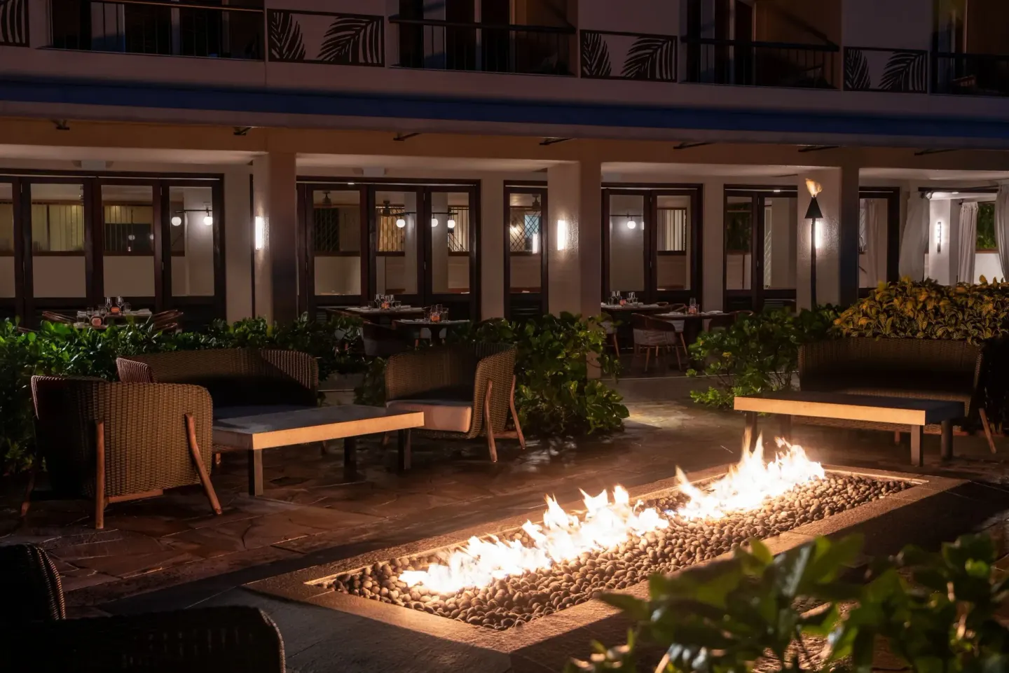 Outdoor fire pit lounge at night at Sheraton Kauai Coconut Beach Resort.
