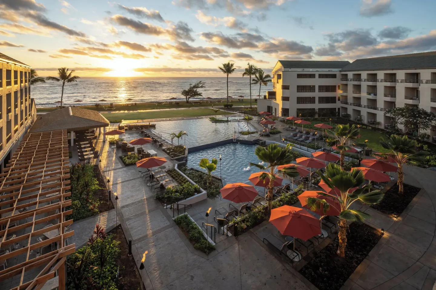 Aerial-style resort pool and ocean view at Sheraton Kauai Coconut Beach Resort at sunrise.