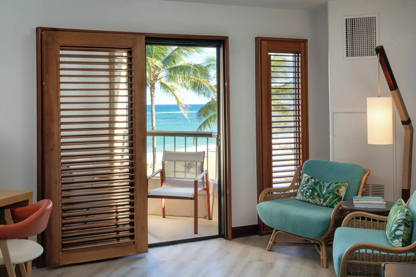 Ocean View guest room lounge chairs and balcony doorway at Sheraton Kauai Coconut Beach Resort.