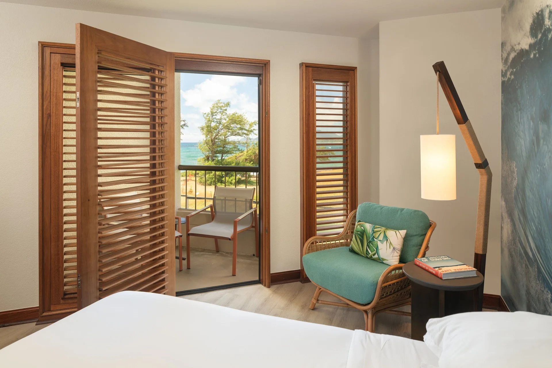 Ocean View guest room seating, balcony, and water beyond at Sheraton Kauai Coconut Beach Resort.