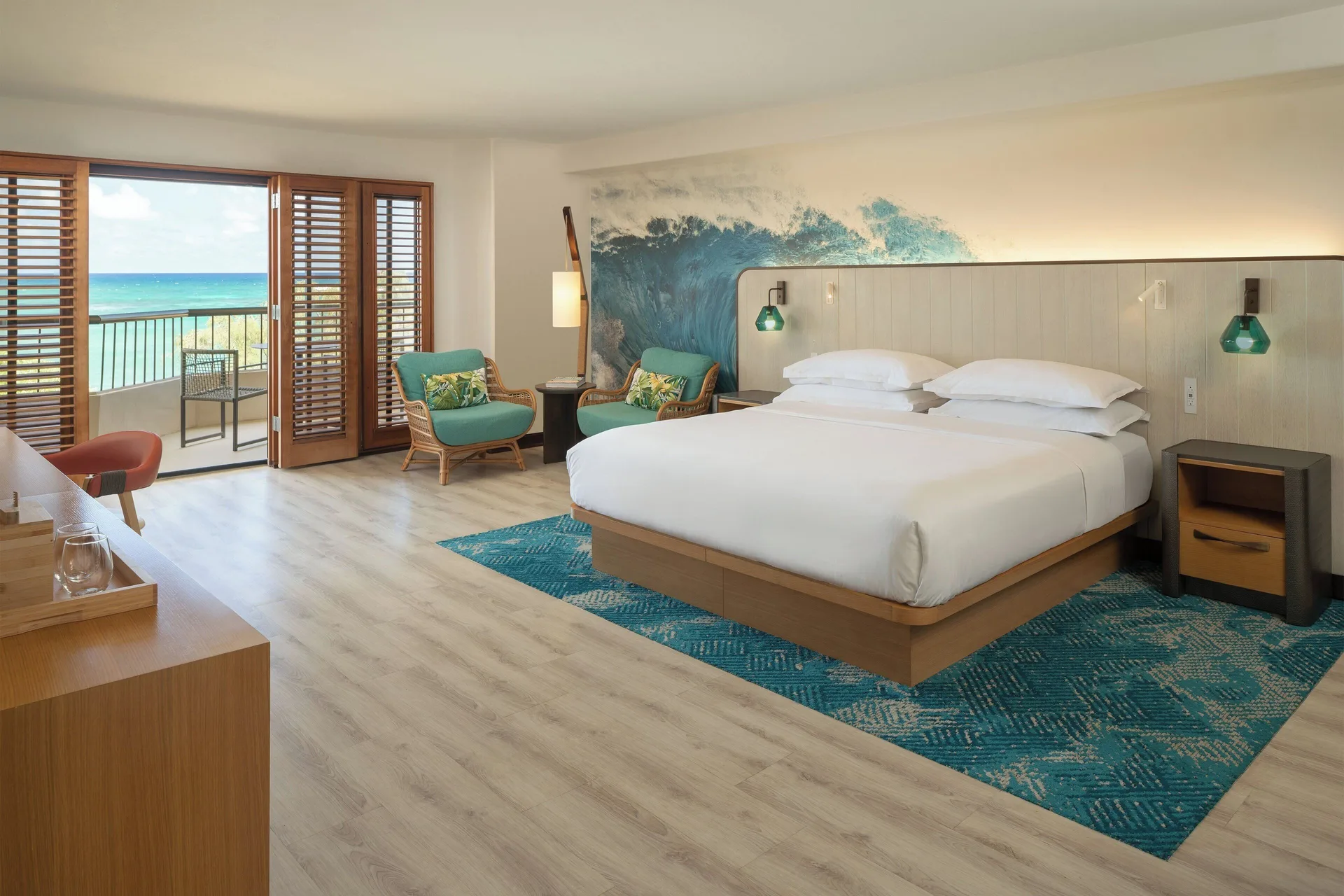 Ocean View guest room with king bed, sitting area, and balcony at Sheraton Kauai Coconut Beach Resort.