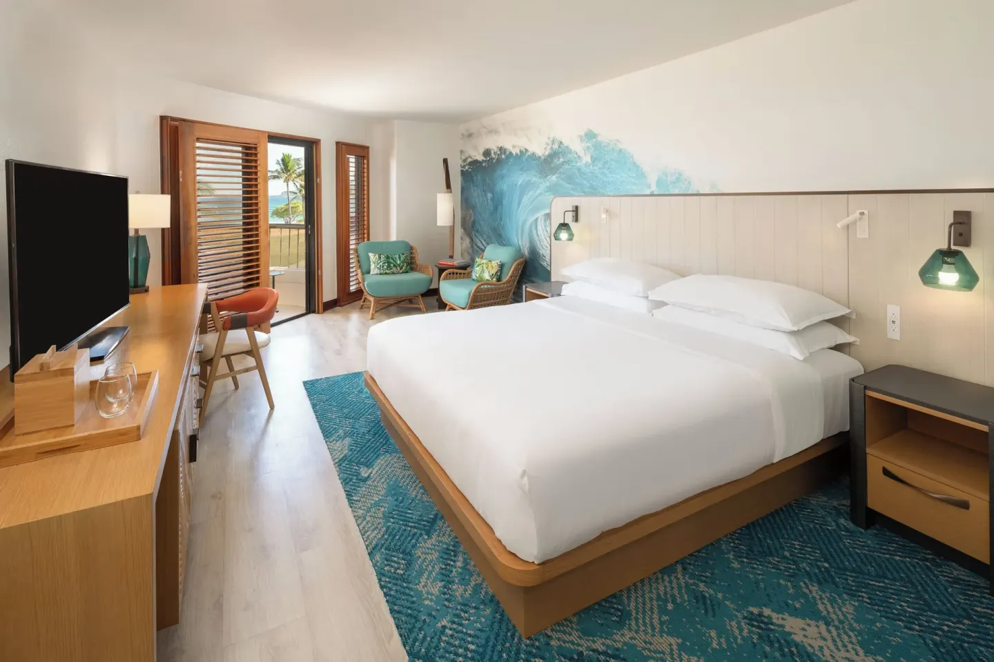 Ocean View king guest room with TV, desk, and balcony doors at Sheraton Kauai Coconut Beach Resort.