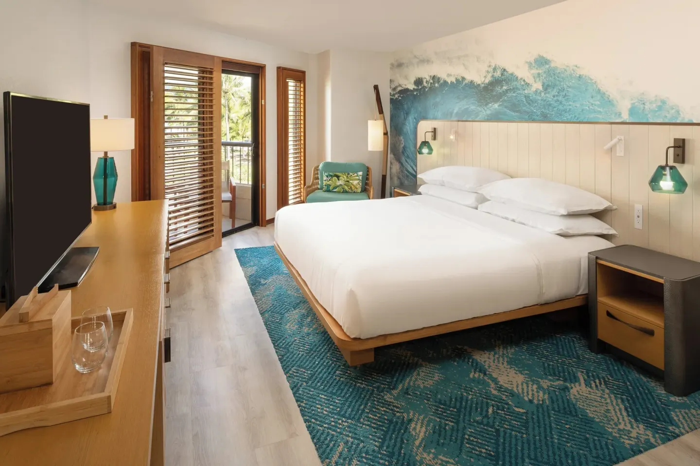 Standard room with king bed, TV, and balcony doors at Sheraton Kauai Coconut Beach Resort.