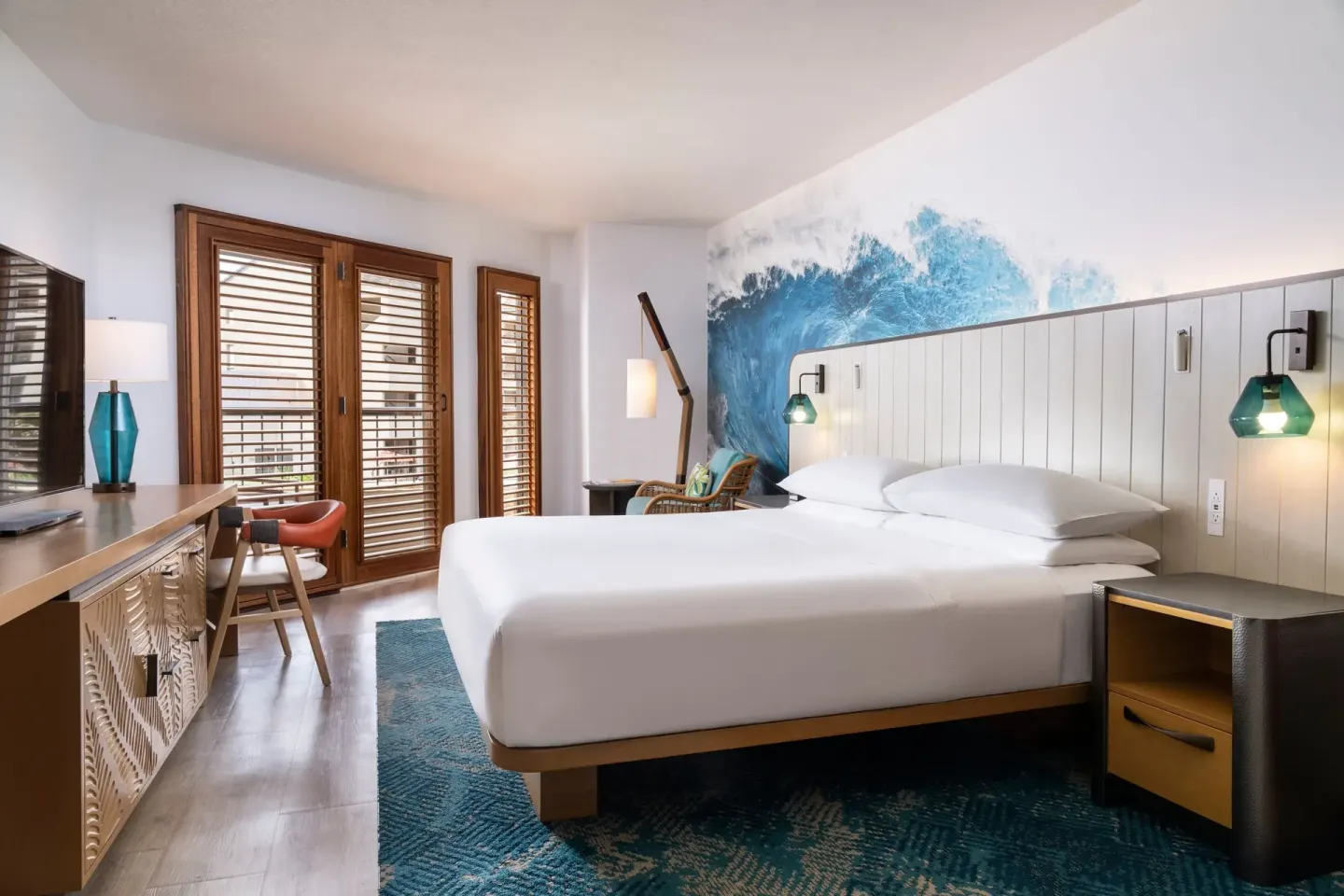 Standard room with king bed and wave mural at Sheraton Kauai Coconut Beach Resort.