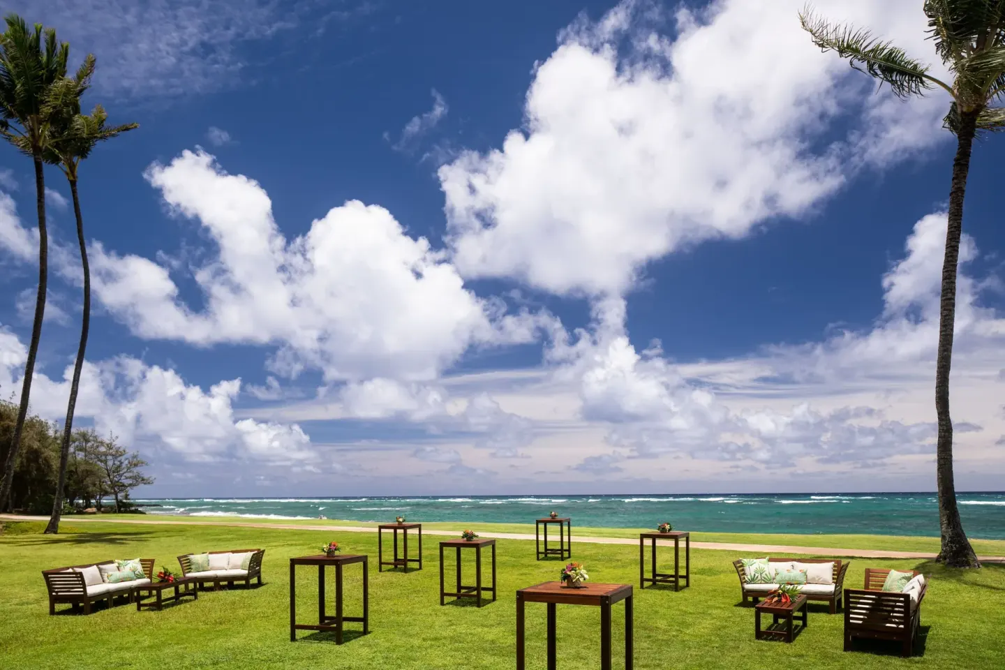 Beachfront lawn event setup at Sheraton Kauai Coconut Beach Resort with lounge seating and ocean views.