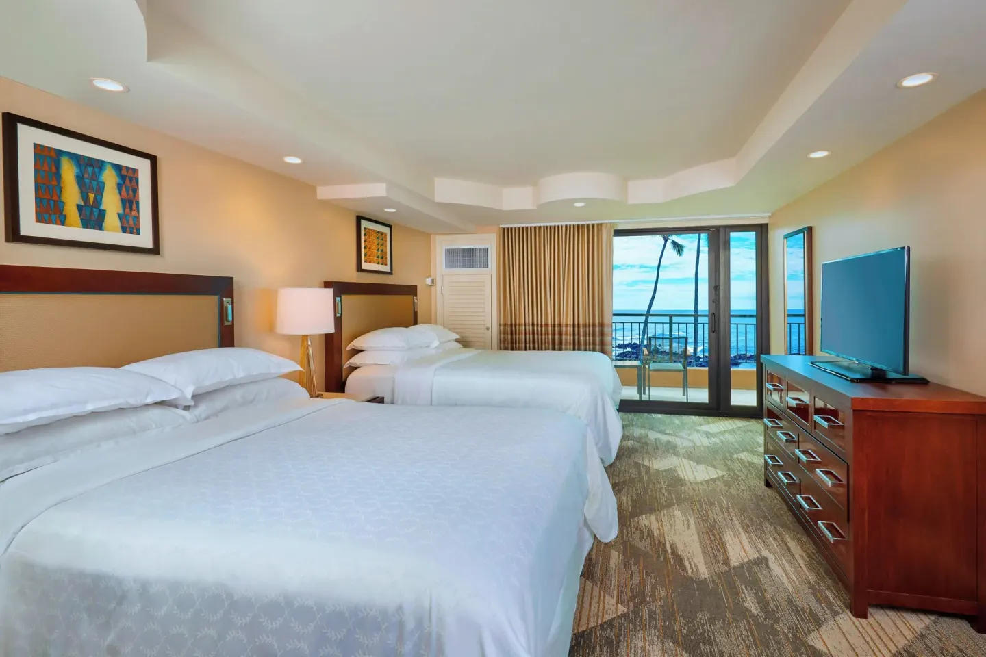 Two-bed ocean view guest room with balcony at Sheraton Kauai Resort.