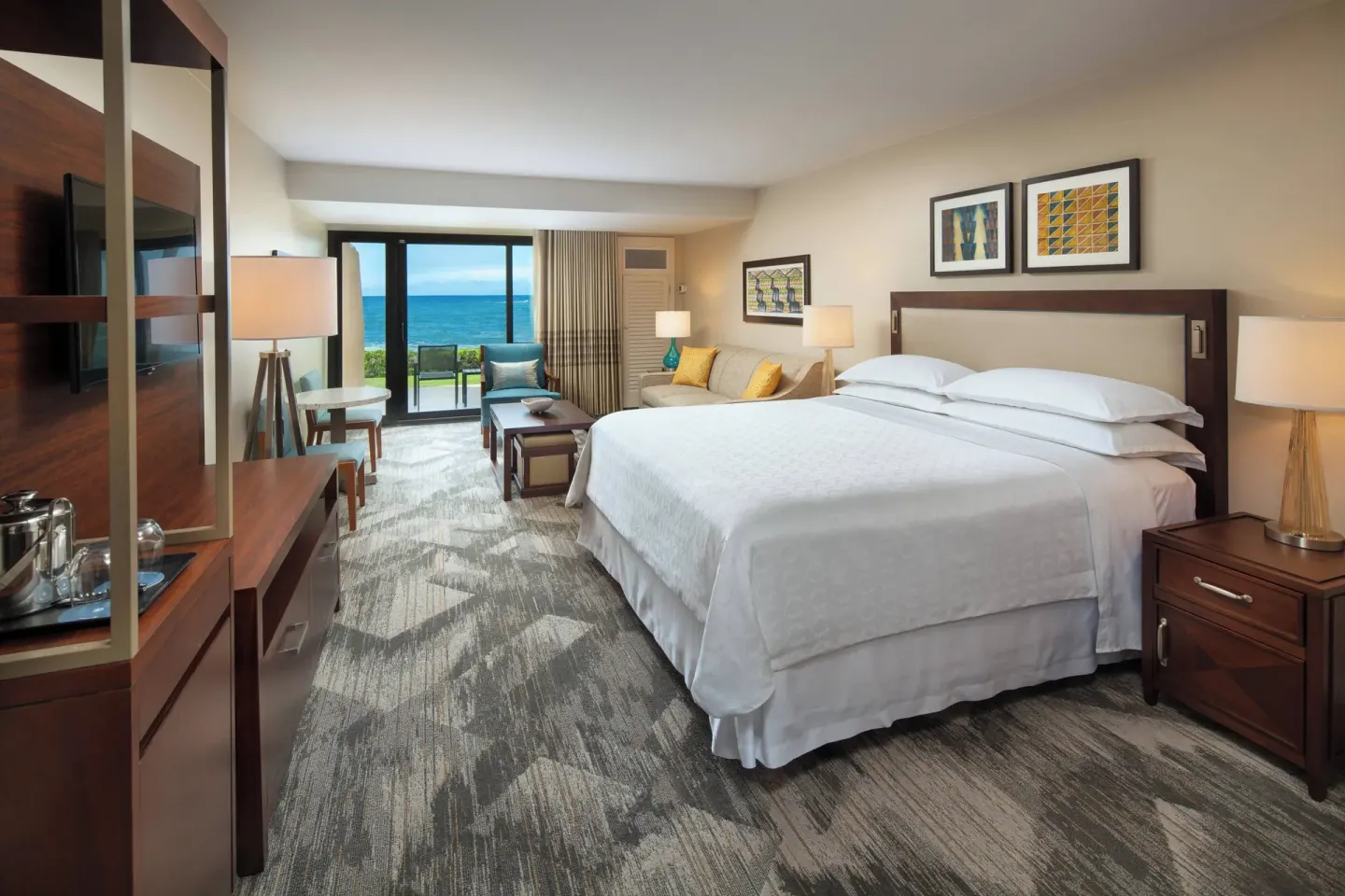 Deluxe Room Oceanfront king bed at Sheraton Kauai Resort with seating and ocean view.