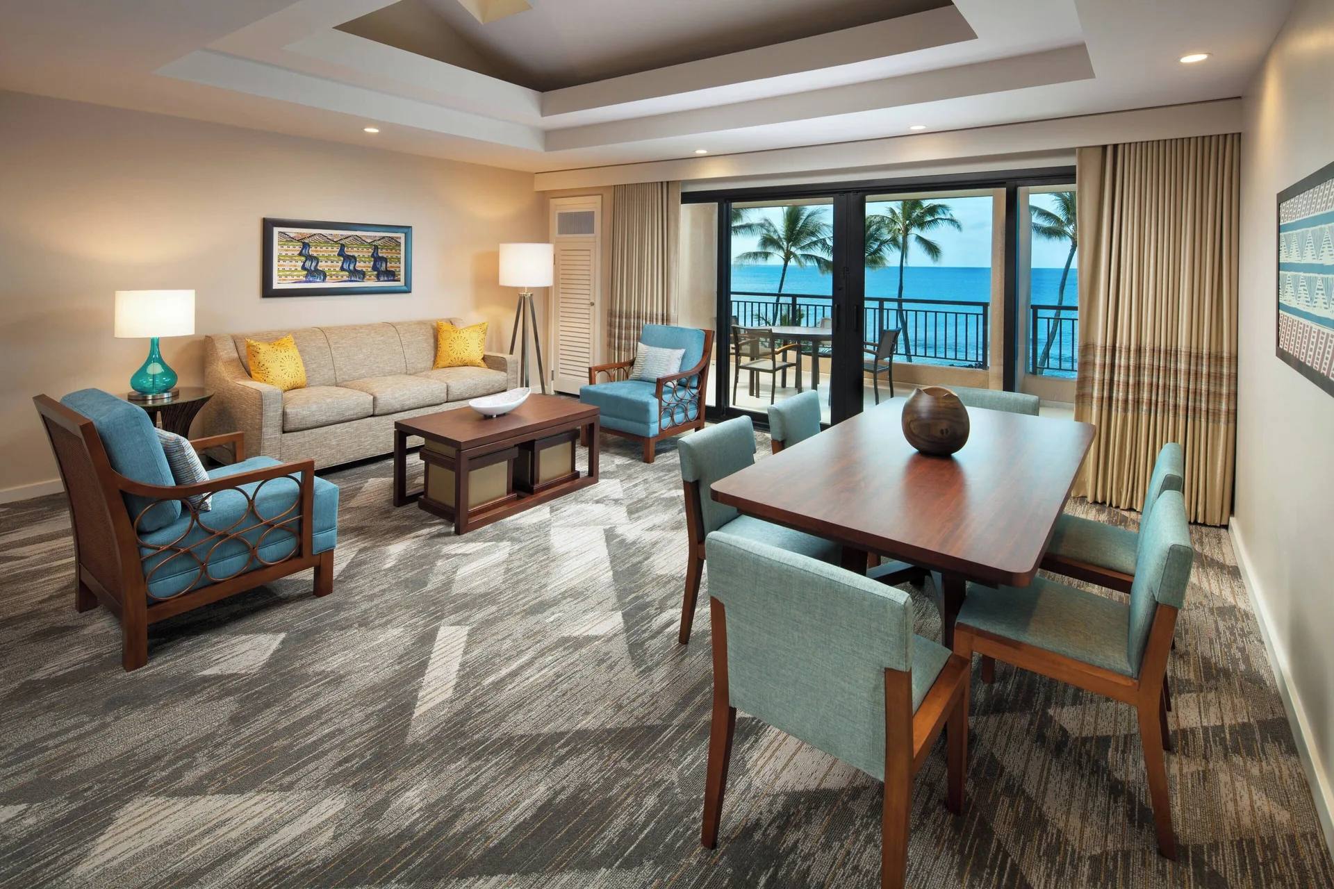 Oceanfront deluxe suite living and dining room with balcony at Sheraton Kauai Resort.