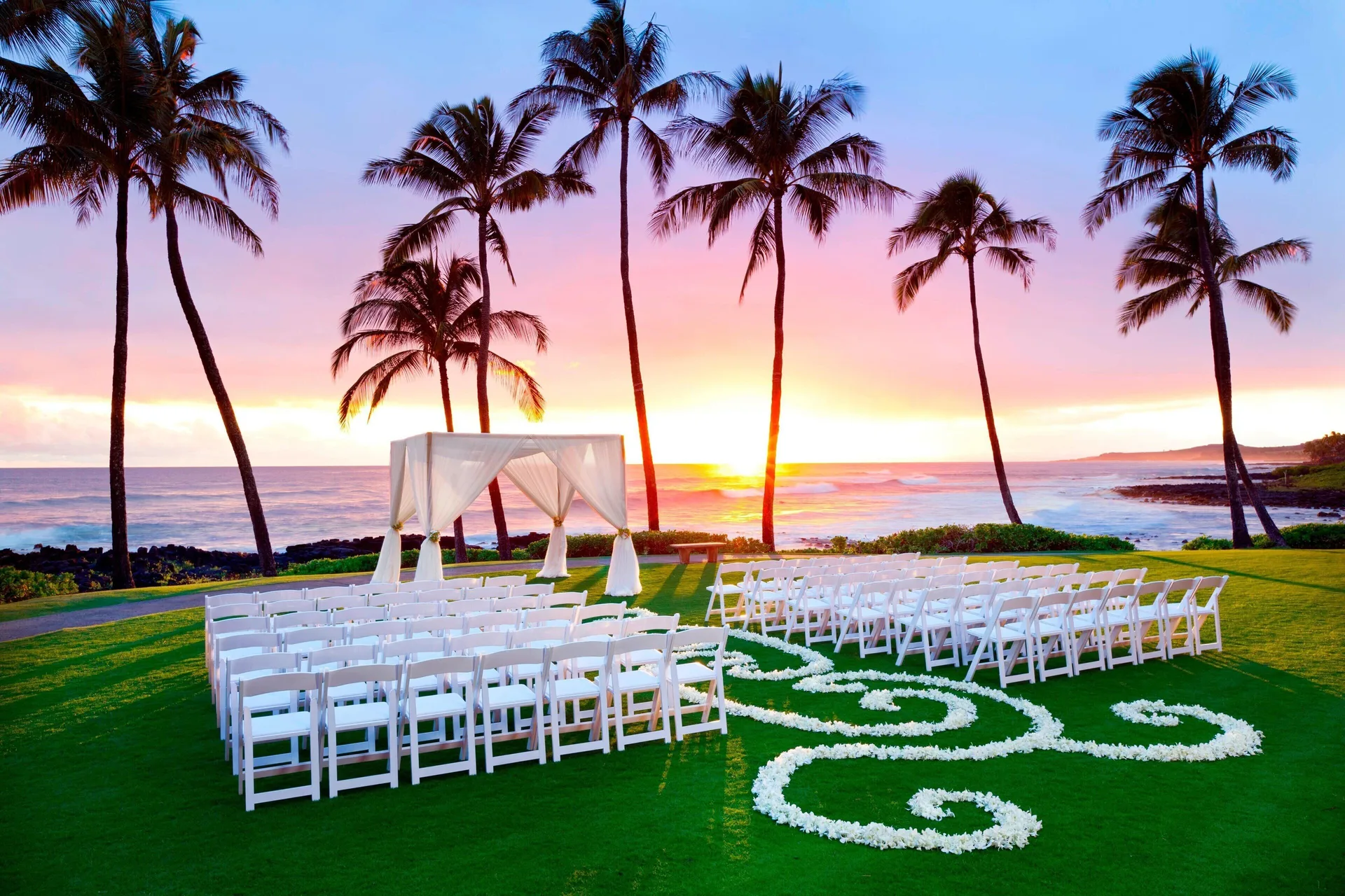 Oceanfront wedding ceremony setup at sunset at Sheraton Kauai Resort.