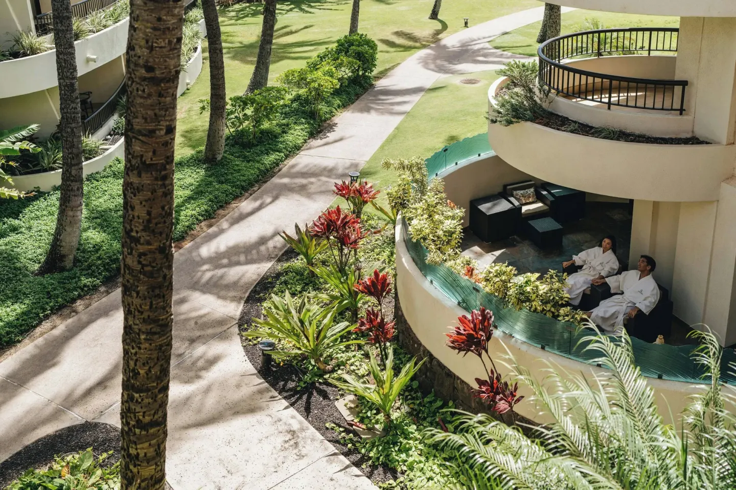 Guests relax on a garden-view balcony at Sheraton Maui Resort & Spa.