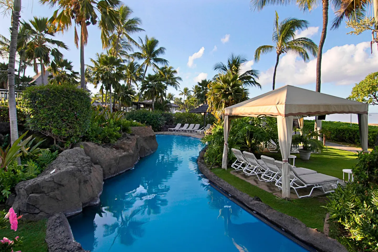 A lagoon-style pool curves through palms and cabanas at Sheraton Maui Resort & Spa.