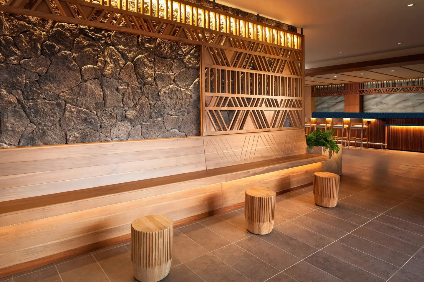 Wood bench seating and stone wall in a lounge area at Sheraton Maui Resort & Spa.
