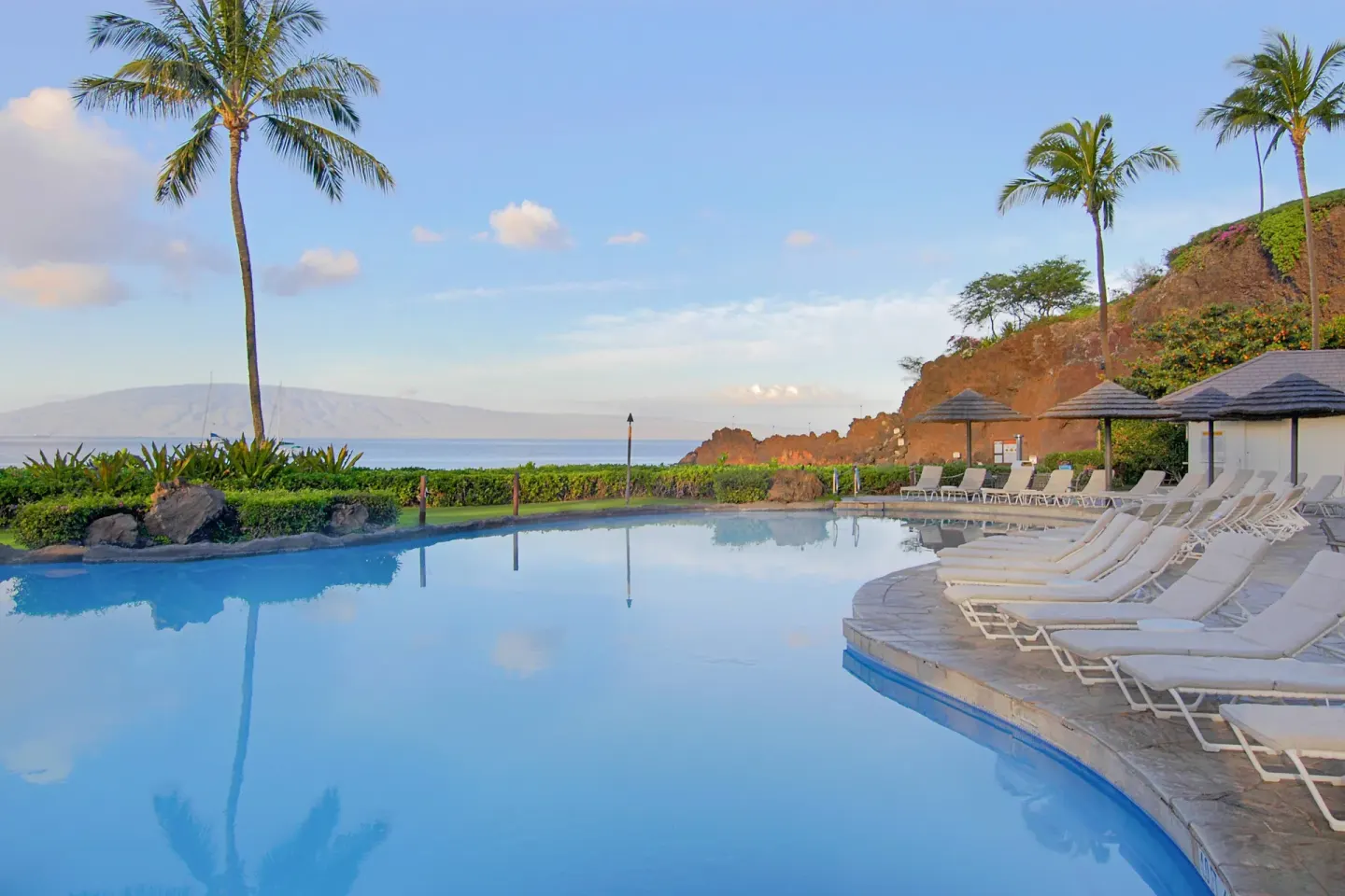 Pool loungers face the ocean and Black Rock at Sheraton Maui Resort & Spa.