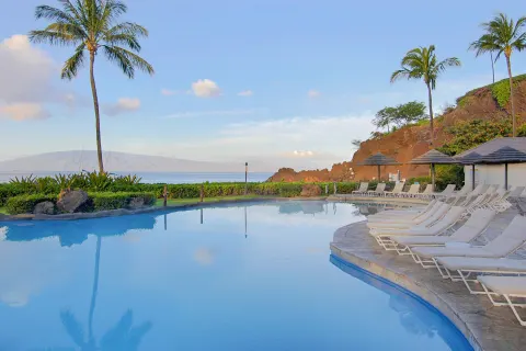 Pool loungers face the ocean and Black Rock at Sheraton Maui Resort & Spa.