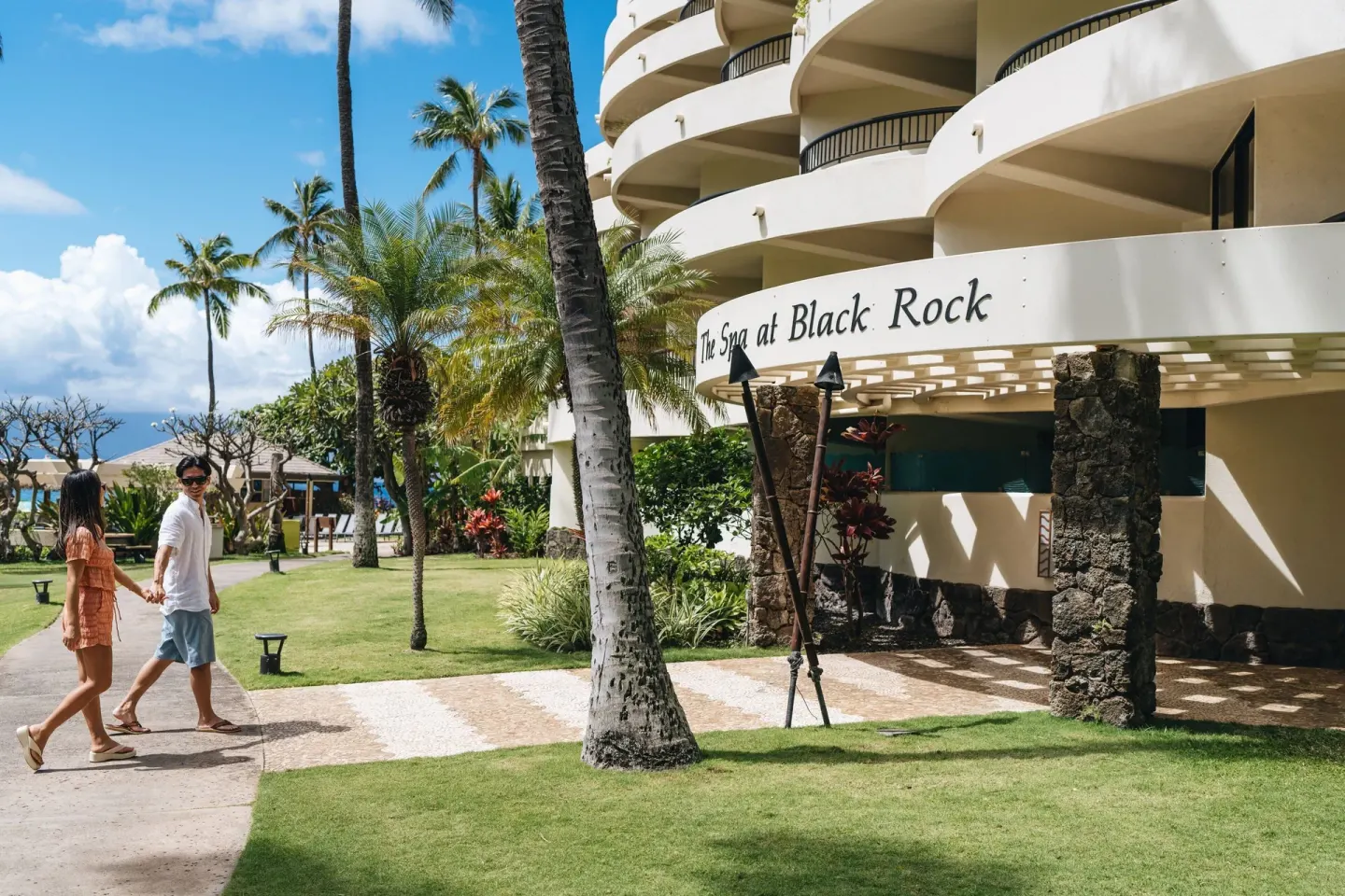 Guests walk past The Spa at Black Rock exterior at Sheraton Maui Resort & Spa.