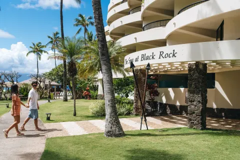 Guests walk past The Spa at Black Rock exterior at Sheraton Maui Resort & Spa.