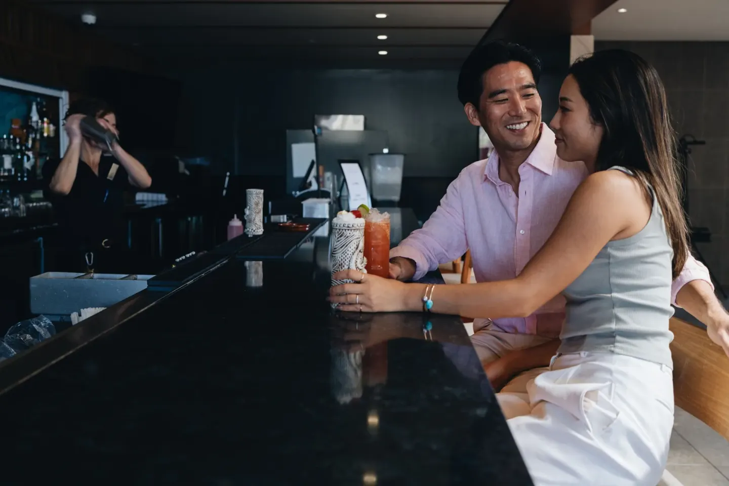 Couple seated at a bar with tropical drinks at Sheraton Maui Resort & Spa.