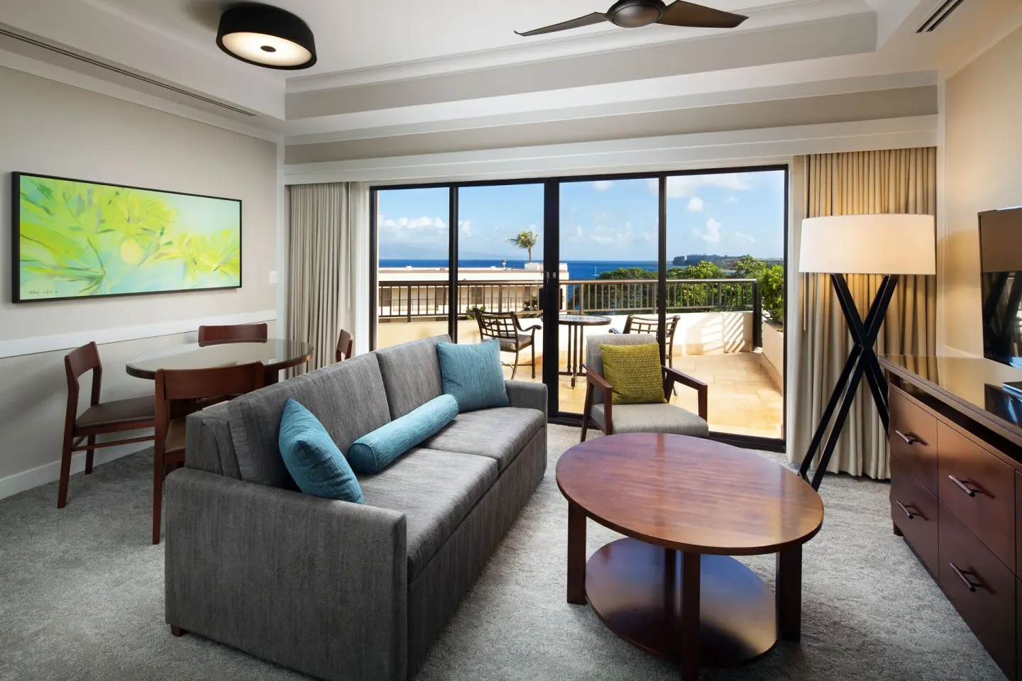 Ocean view suite living room with sofa and balcony at Sheraton Maui Resort & Spa.