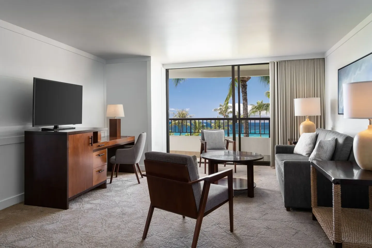 Ocean view suite sitting area with sofa and balcony at Sheraton Maui Resort & Spa.
