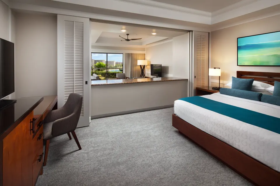 Deluxe Suite oceanfront bedroom with king bed and connected living room at Sheraton Maui Resort & Spa.