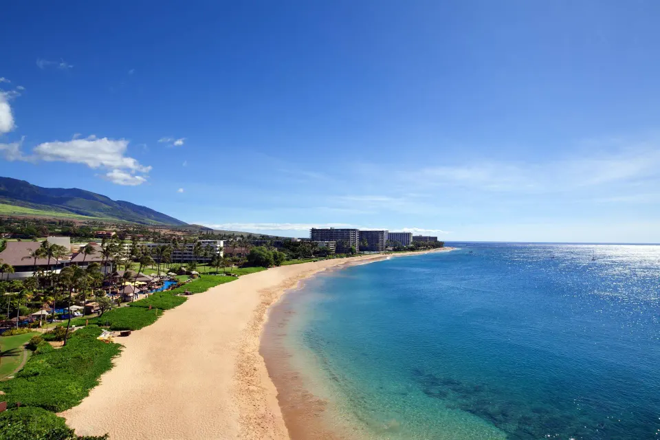 Oceanfront view from the Deluxe Suite over beach, blue water and coastline at Sheraton Maui Resort & Spa.