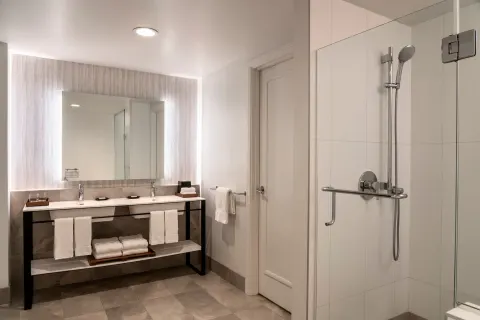 Moana Oceanfront Suite bathroom with double vanity and glass shower at Sheraton Maui Resort & Spa.