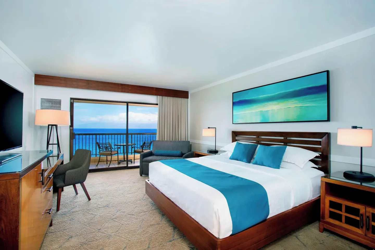 Moana Oceanfront king room with sofa, desk, and balcony at Sheraton Maui Resort & Spa.